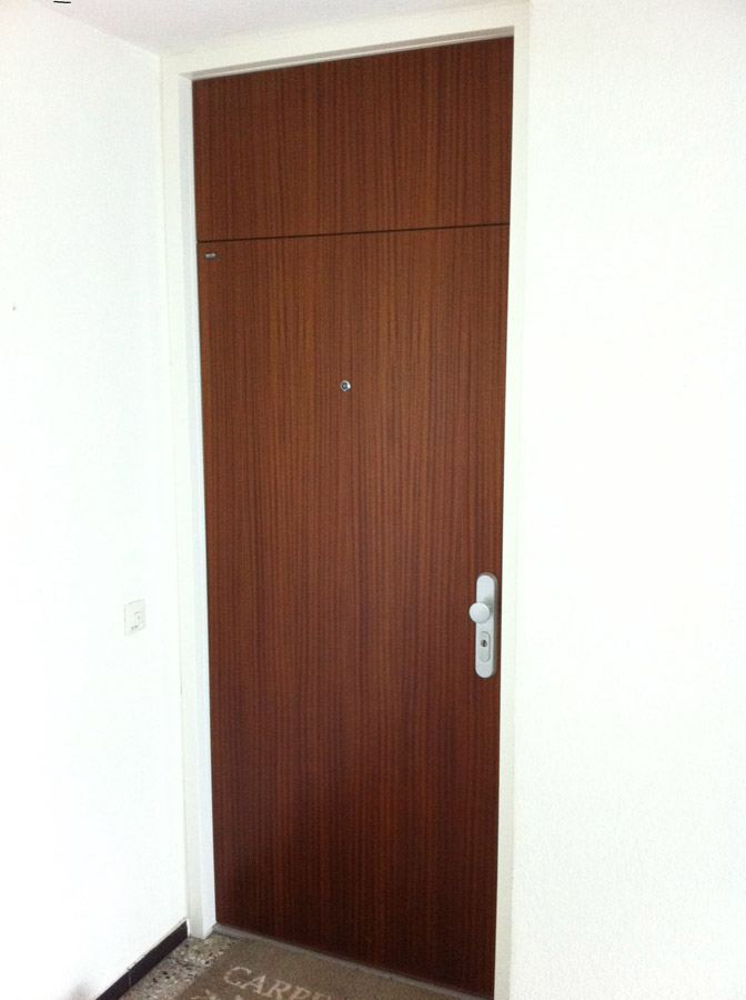 Hohe Wohnungstür in dunklem Holzdekor mit integriertem Oberteil